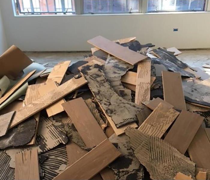Pile of damaged floor boards removed during water damage mitigation